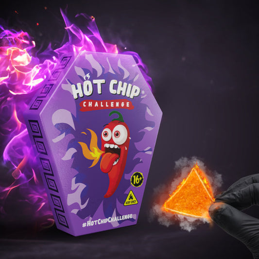 Paquet de chips HOT-CHIP Challenge avec une chips enflammée dans une main gantée, parfait pour les défis sauce piquante et huile piquante.